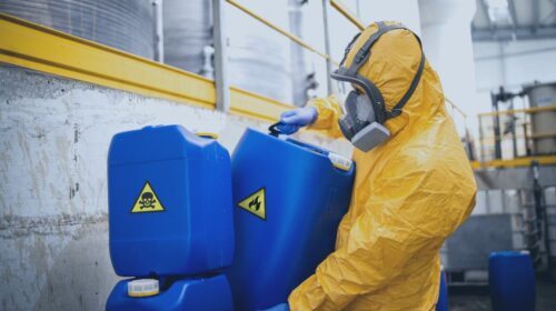 Worker handling hazardous solvents in textile manufacturing facility